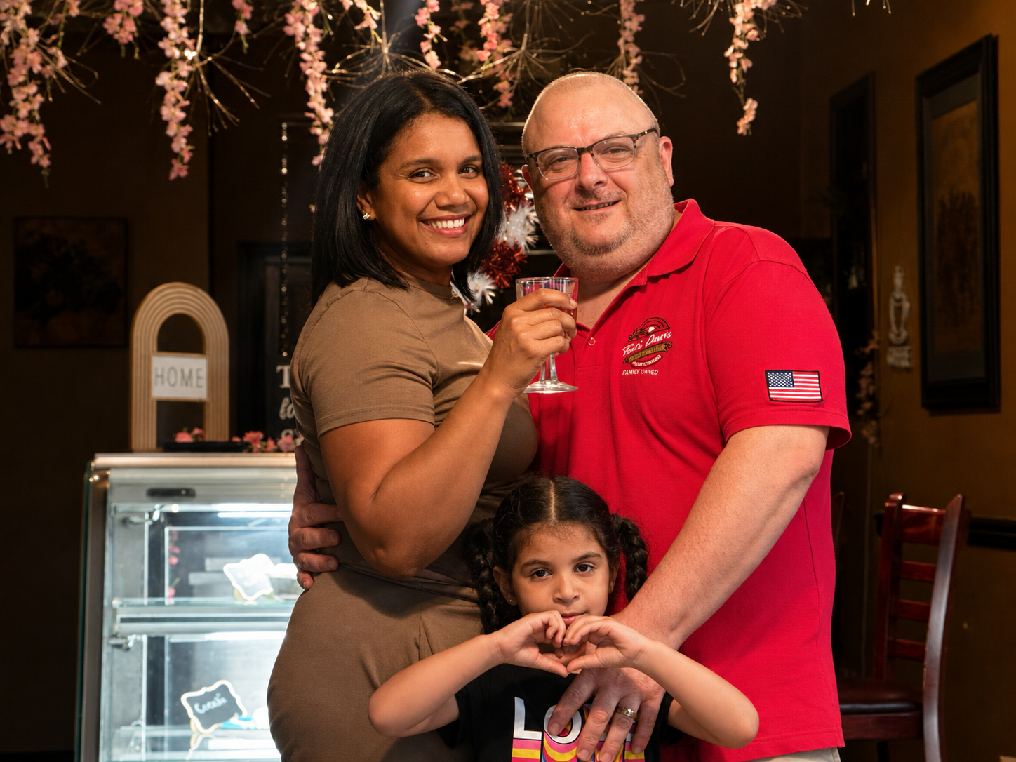 Owners toasting with their daughter inside That's Amore